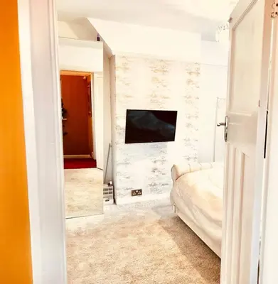 a bedroom with a bed and a tv on a wall at Liverpool - Cosy Jazzy Beach Home! in Waterloo