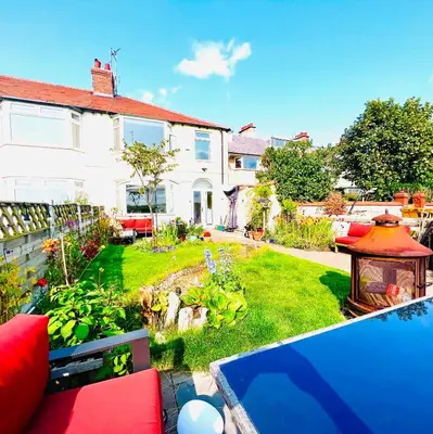 a garden with a house and a swimming pool at Liverpool - Cosy Jazzy Beach Home! in Waterloo
