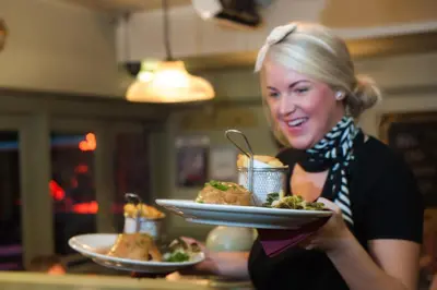 a woman is holding a plate of food at The Borough Lancaster in Lancaster