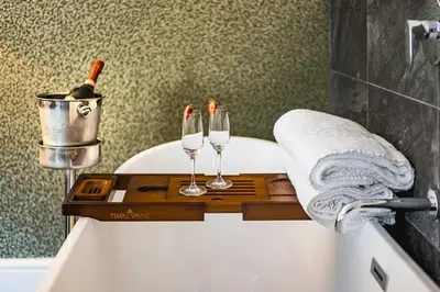 a bathroom with two wine glasses on a bath tub at The Borough Lancaster in Lancaster