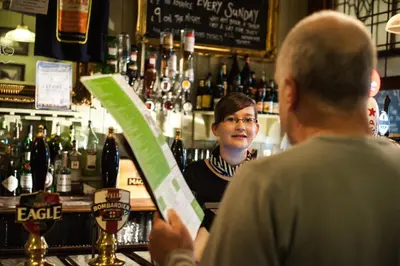 a man standing at a bar talking to a woman at The Borough Lancaster in Lancaster