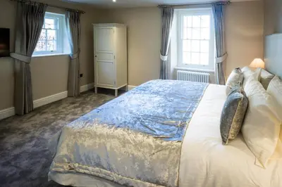 a bedroom with a large bed and two windows at The Borough Lancaster in Lancaster