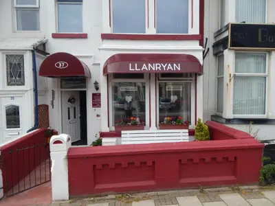 a red bench in front of a building at Llanryan Guest House in Blackpool