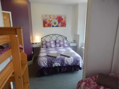 a bedroom with a bed with purple pillows at Llanryan Guest House in Blackpool