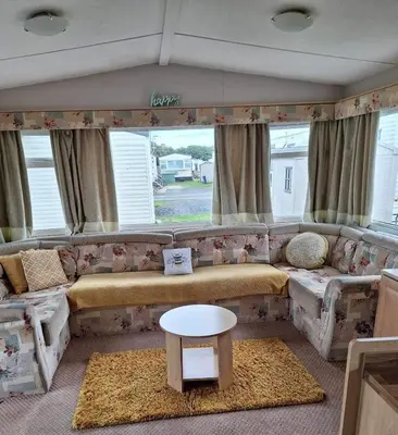 a living room with a couch and a table at Marina Retreat in Haverigg