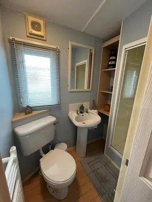 a small bathroom with a toilet and a sink at Marina Retreat in Haverigg