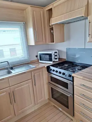 a kitchen with a stove and a microwave at Marina Retreat in Haverigg