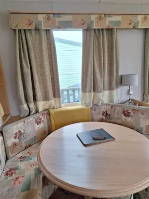 a table with a book on it in a living room at Marina Retreat in Haverigg