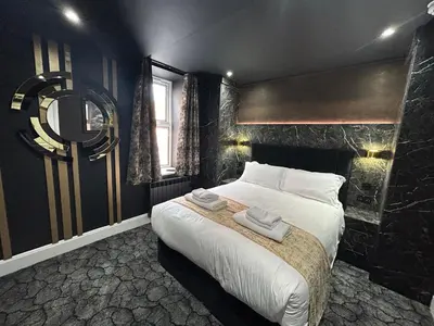 a bedroom with a large bed with two towels on it at Swish Luxury Holiday Apartments in Blackpool