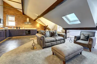 a living room with two chairs and a table at Swish Luxury Holiday Apartments in Blackpool