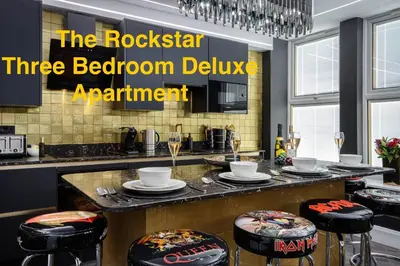 a kitchen with a counter with stools in front at Swish Luxury Holiday Apartments in Blackpool