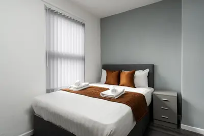 a bedroom with a large bed with two towels on it at Vichy - Strathcona Suites, 3 beds houses in Wavertree in Liverpool