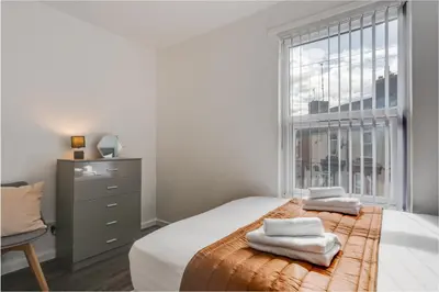 a bedroom with a bed and a window with towels on it at Vichy - Strathcona Suites, 3 beds houses in Wavertree in Liverpool