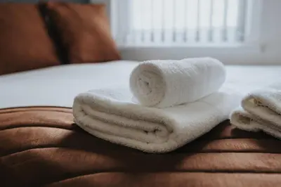 a pile of towels sitting on top of a bed at Vichy - Strathcona Suites, 3 beds houses in Wavertree in Liverpool