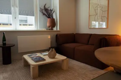a living room with a brown couch and a table at LIVINGWAY Roco in Liverpool