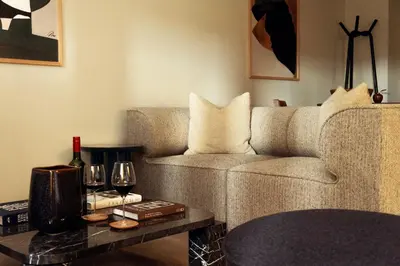 a living room with a couch and a table with wine glasses at LIVINGWAY Roco in Liverpool