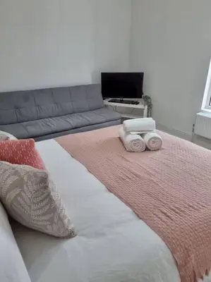 a bedroom with a bed with two towels on it at Cosy modern house in Liverpool