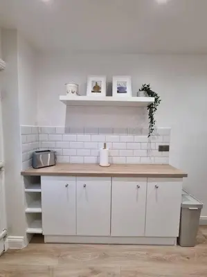 a kitchen with white cabinets and a counter top at Cosy modern house in Liverpool
