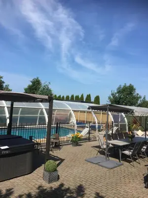 a patio with tables and chairs and a swimming pool at FLETCHERS HALL COVERED POOL Heated in Freckleton