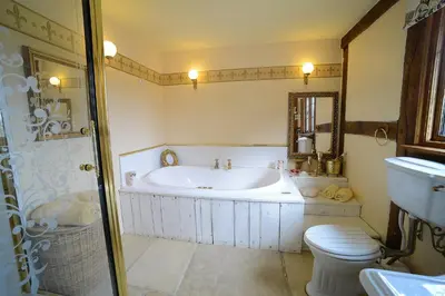 a bathroom with a tub and a toilet and a sink at FLETCHERS HALL COVERED POOL Heated in Freckleton