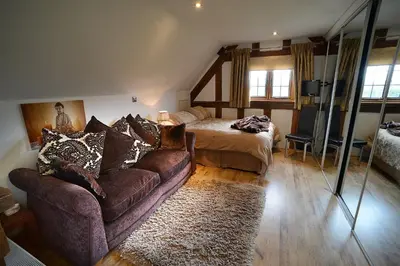 a living room with a couch and a bed at FLETCHERS HALL COVERED POOL Heated in Freckleton