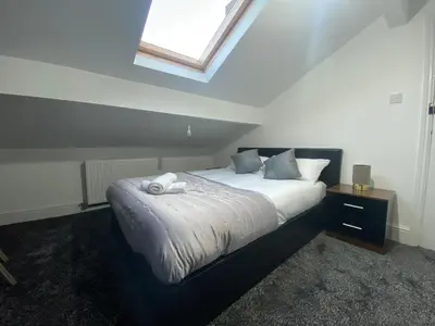 a bedroom with a large bed with a skylight at BEST CHOICE - Hotel Royal in Blackburn