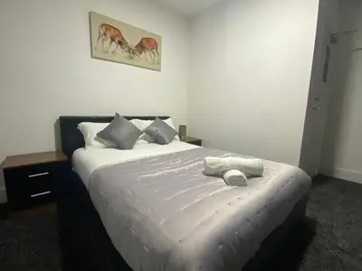 a bedroom with a large bed with white sheets at BEST CHOICE - Hotel Royal in Blackburn