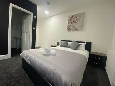a bedroom with a large bed with a towel on it at BEST CHOICE - Hotel Royal in Blackburn