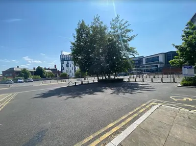 an empty parking lot with a tree in the middle at BEST CHOICE - Hotel Royal in Blackburn
