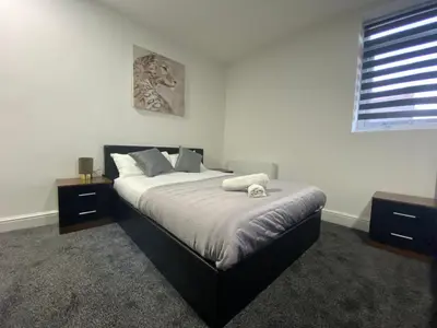 a bedroom with a large bed with white sheets and a window at BEST CHOICE - Hotel Royal in Blackburn