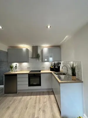a kitchen with white cabinets and a counter top at The Cottage in Saint Annes on the Sea