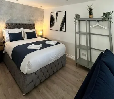 a bedroom with a large bed and a shelf at The Cottage in Saint Annes on the Sea