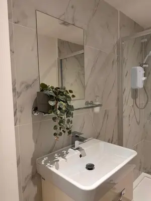 a bathroom with a white sink and a mirror at The Cottage in Saint Annes on the Sea