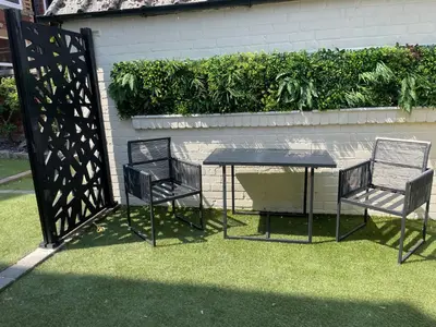 two chairs and a table in front of a fence at The Cottage in Saint Annes on the Sea