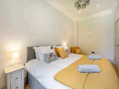 a bedroom with a large white bed with pillows at Mishmash in Arnside