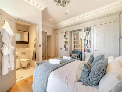 a bedroom with a large white bed with blue pillows at Mishmash in Arnside