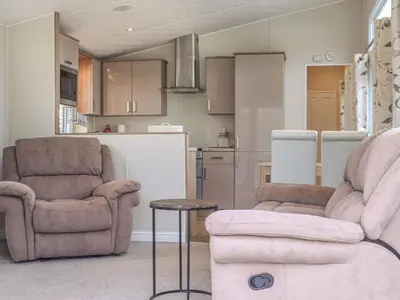 a living room with two chairs and a table at Tiptoes Lodge in Carnforth