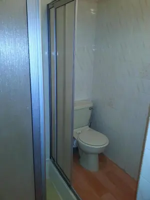 a bathroom with a toilet and a glass shower at Jesmond International Hotel in Blackpool