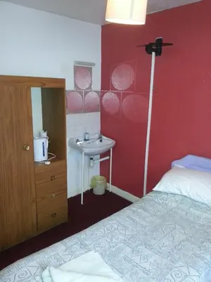 a bedroom with a bed and a sink at Jesmond International Hotel in Blackpool