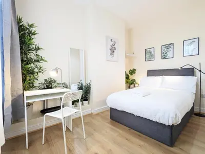 a bedroom with a bed and a desk and a table at Guest Rooms in Anfiled Near Stadium, Free Parking in Liverpool