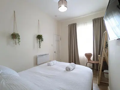a bedroom with a white bed with towels on it at Guest Rooms in Anfiled Near Stadium, Free Parking in Liverpool