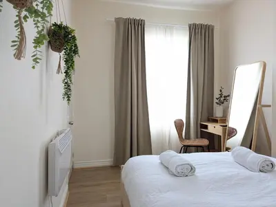 a bedroom with a bed and a mirror and a window at Guest Rooms in Anfiled Near Stadium, Free Parking in Liverpool