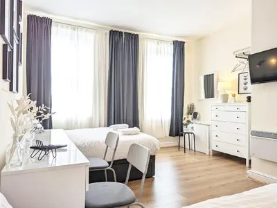 a hotel room with two beds and a desk at Guest Rooms in Anfiled Near Stadium, Free Parking in Liverpool