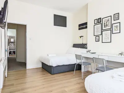 a bedroom with two beds and a desk and chairs at Guest Rooms in Anfiled Near Stadium, Free Parking in Liverpool