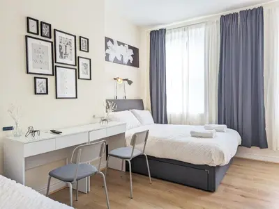 a bedroom with a bed with a desk and two chairs at Guest Rooms in Anfiled Near Stadium, Free Parking in Liverpool