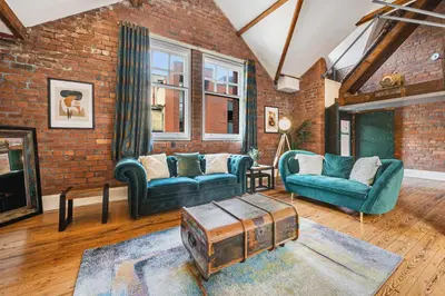 a living room with two couches and a brick wall at Host & Stay - Bands Warehouse VI in Liverpool