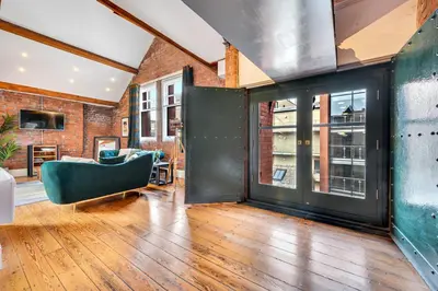 an open living room with a couch and windows at Host & Stay - Bands Warehouse VI in Liverpool