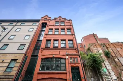 a tall red brick building with windows on a street at Host & Stay - Bands Warehouse VI in Liverpool