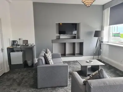 a living room with a couch and a table at Royal Seabank Hotel in Blackpool