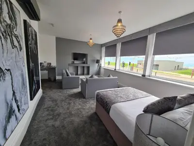 a bedroom with a bed and a living room at Royal Seabank Hotel in Blackpool